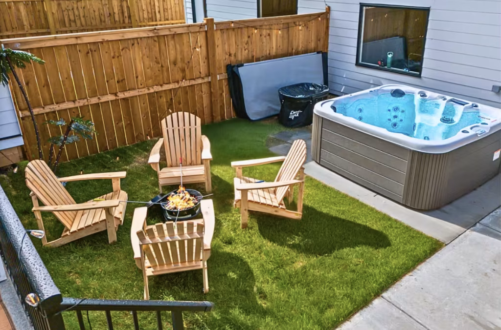 Private fenced yard with fire pit and hot tub at Tuxedo BnB