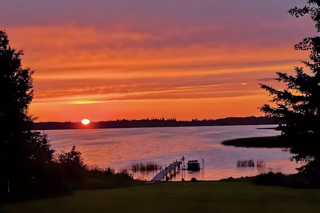 Sunset over the water at the Lessard Lake waterfront log home